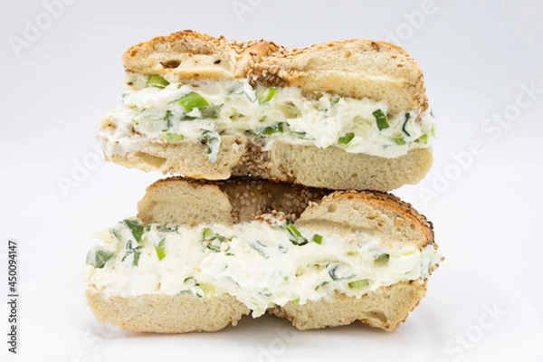 Obraz A Cut in Half and Stacked New York Style Sesame Seed Bagel filled with Scallion Cream Cheese