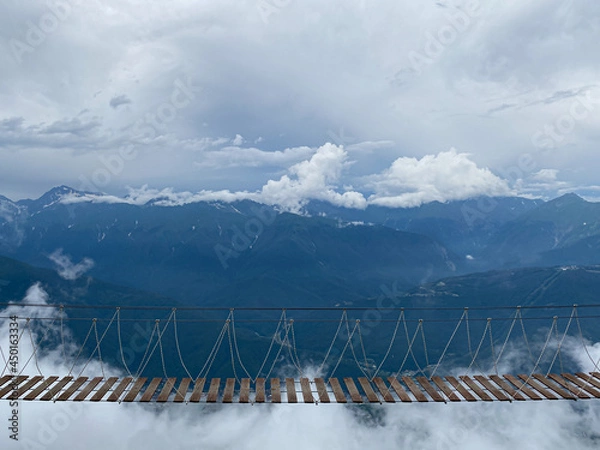 Obraz Rope bridge in the mountains at a height in the clouds