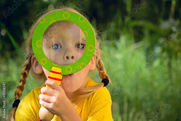 Fototapeta Девочка смотрит удивленно через лупу
