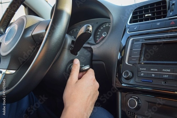 Fototapeta 
The hand of the man, whose face is not visible, is on the ignition key in the car
