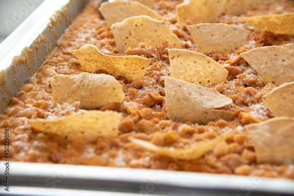 Fototapeta beans with tortilla chips on top served in a tray
