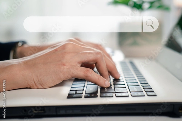 Obraz Hand typing on keyboard with search engine toolbox