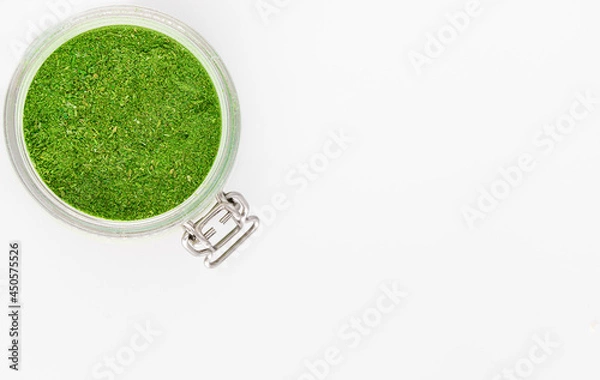 Obraz Green spices in a glass jar on a white background. Culinary spices.