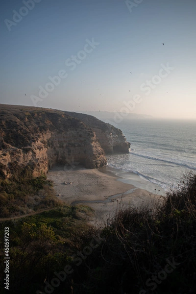 Fototapeta A hidden beach between cliffs with shrubbery in Maitencillo, Chile