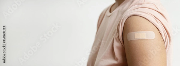 Fototapeta Asia woman showing shoulder with plaster bandage has gone to vaccinate coronavirus covid19, Healthcare And Inoculation Concept