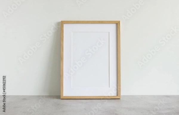 Fototapeta Frame mockup template on white wall  background on gray concrete desk. Copy space. Minimal concept. Interior wall accessories.
