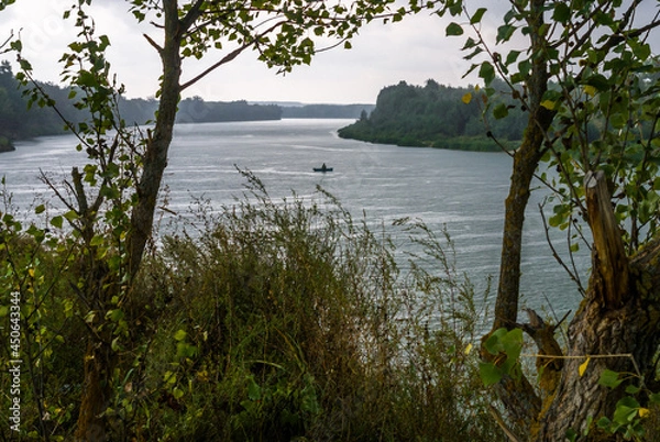 Obraz River with a fishing boat in the rain