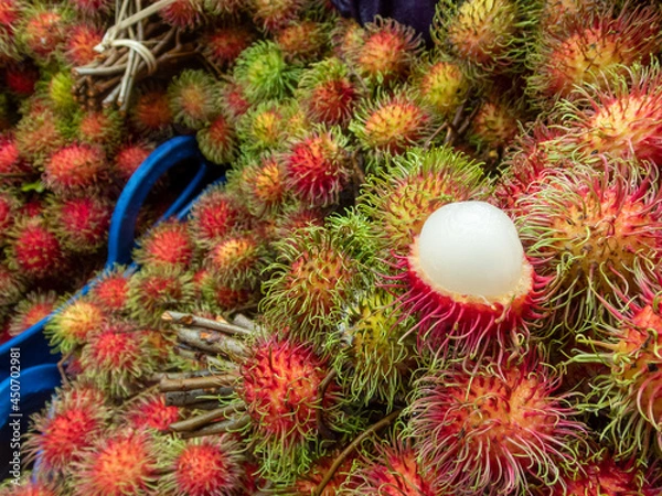 Fototapeta Choose focus rambutan large casing. Show off the white flesh that is firm and appetizing. Red peeled fruit from the Thai garden during the rainy season Rambutan in the fresh fruit market