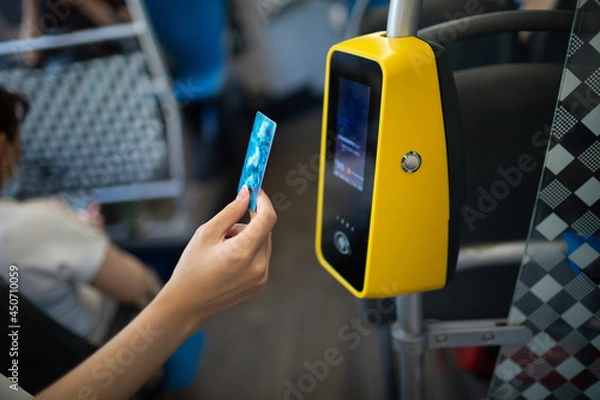 Fototapeta Asian woman hand paying conctactless with plastic card for the public transport in bus, tram or subway metro close up