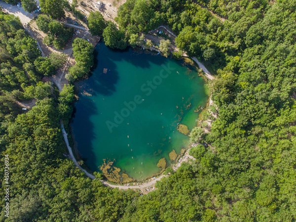 Obraz Round small lake with clear water sorrounded by trees , overhead view