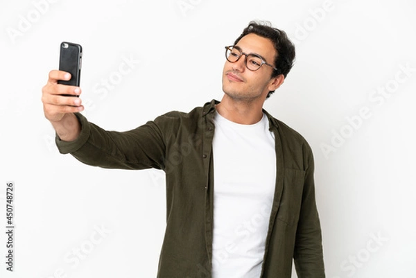 Fototapeta Caucasian handsome man over isolated white background making a selfie