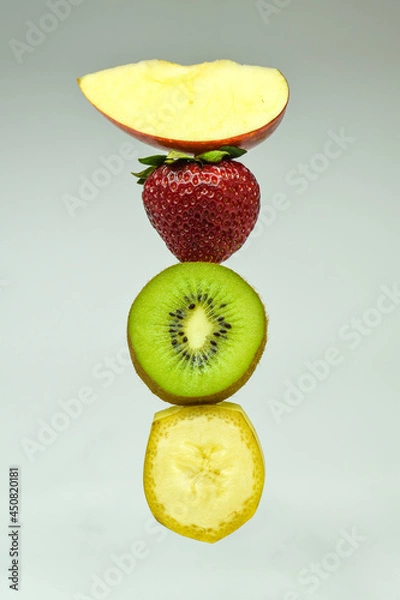 Fototapeta Apple, strawberry, kiwi and banana on light background