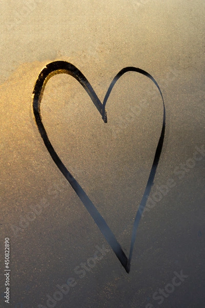 Fototapeta heart on beige background, symbol heart painted on misted glass, texture of frost and water drops, empty space for inscription. vertical frame out of focus