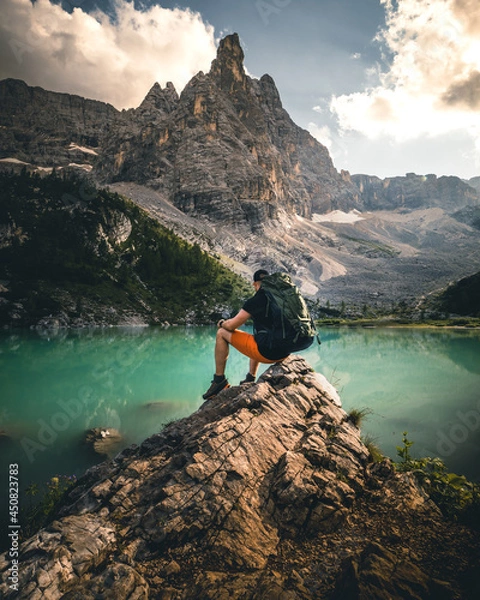 Fototapeta hiker man with backpack at mountain lake lago di sorapis in the dolomites during summer