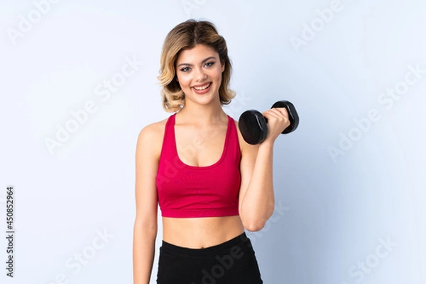 Obraz Teenager Russian girl making weightlifting isolated on blue background with sad expression