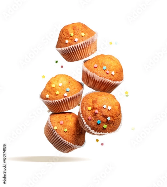 Fototapeta Fly delicious vanilla cupcakes. Cupcakes in paper liners with colorful icing stars fly isolated on white background.