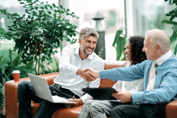 Obraz business partners greeting each other with a handshake.