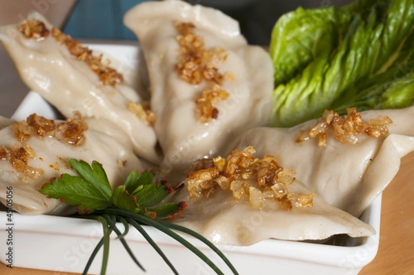 Obraz Ruskie Pierogi podane z smażoną cebulką, sałatą i szczypiorkiem