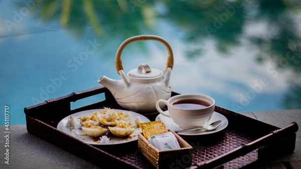 Fototapeta Afternoon tea with white Chinese style kettle and cup side of pool with natural light