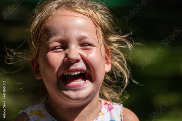 Fototapeta the child is crying and laughing, the child is hysterical