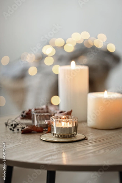 Fototapeta Cozy home composition with candles on blurred bokeh background.