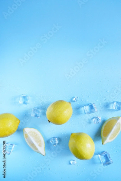Fototapeta Frame, lay out ice cubes, lemons  and water drops on the blue background. Summer vibes. Cooling fresh humid template composition. Empty space for text on the top. Flyer, card, invitation.