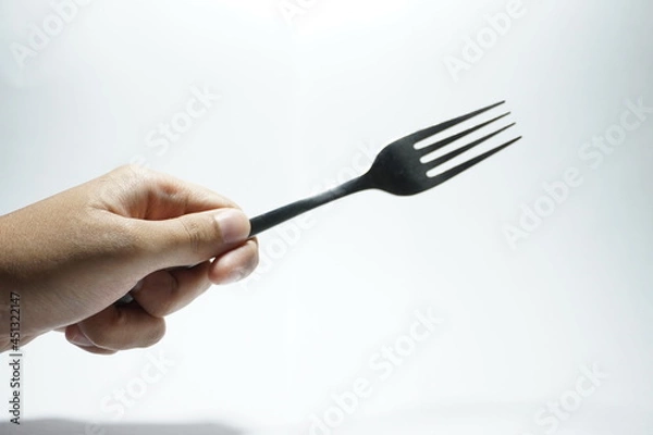 Fototapeta a hand holding a fork, on a white background