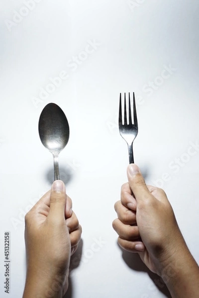 Fototapeta hands holding fork and spoon