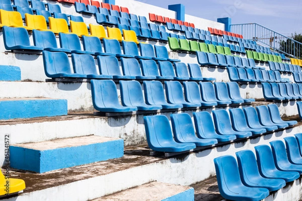 Fototapeta Empty old blue seats in the blue,yellow green and red in stadium.