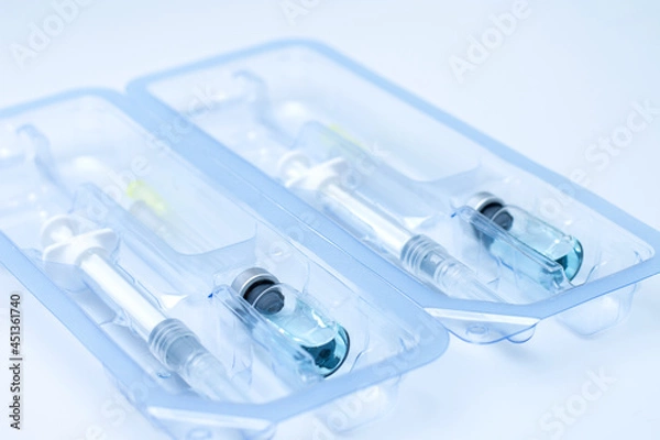 Obraz Covid-19, flu, coronavirus liquid vaccine vial bottle and syringe set in plastic package container preparing for injection on white background. Vaccination for fight Covid-19 virus concept.