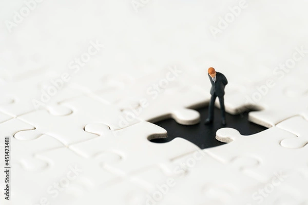 Fototapeta Miniature people Group Business man mini figures standing thinking on Jigsaw Puzzle white background copy space using as thinking business plan and how to solve problem Strategy Planning concepts