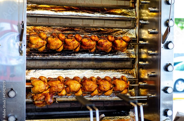Fototapeta Roasted chickens on spit grilled over fire