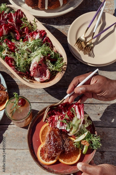 Obraz Person with a plate of food at an outdoor dinner party