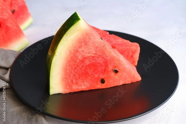 Fototapeta A slice of watermelon on a light blurred background. Berry. The fruit.