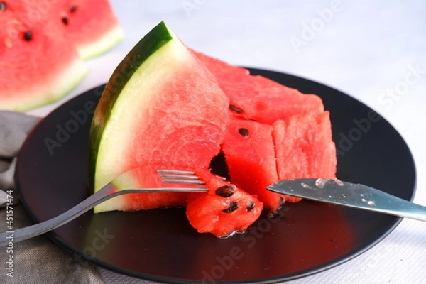 Fototapeta A slice of watermelon on a light blurred background. Berry. The fruit.