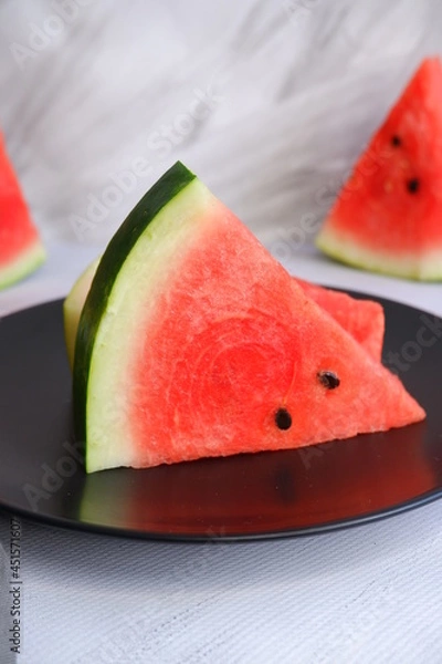 Fototapeta A slice of watermelon on a light blurred background. Berry. The fruit.