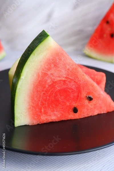 Fototapeta A slice of watermelon on a light blurred background. Berry. The fruit.