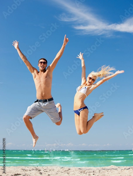 Obraz szczęśliwa para skoki na plaży