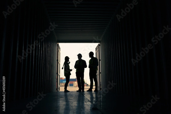 Fototapeta silhouette Group of staff worker standing and checking the containers box from cargo ship for export and import