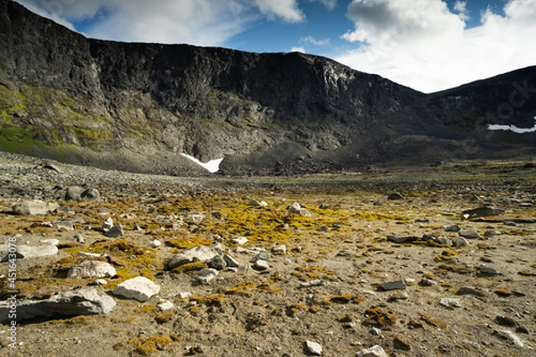 Fototapeta The bottom of a dried mountain lake with stones and moss