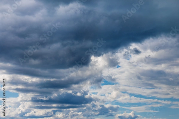 Fototapeta Light and dark clouds on blue sky. Colorful cloudscape background.
