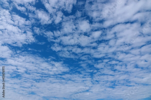 Fototapeta White tiny clouds over blue sky background. Beautiful view of natural scene at sunny day.