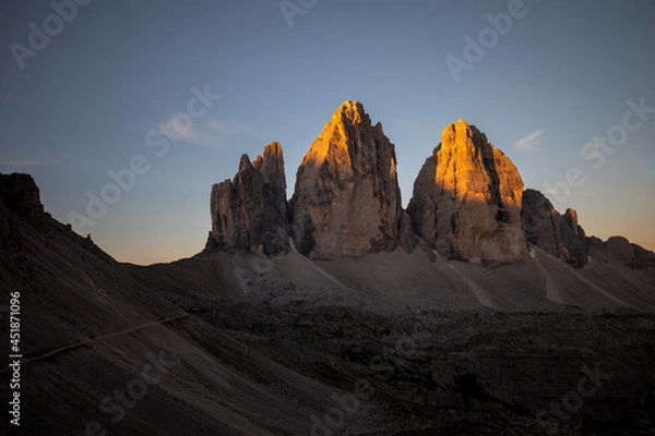 Fototapeta Three peaks of Lavaredo (Drei Zinnen or Tre Cime di Lavaredo) in the Sexten Dolomites National Park during sunrise with light on the peaks