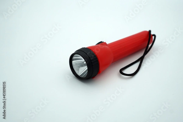 Obraz A small red flashlight on a white isolated background  