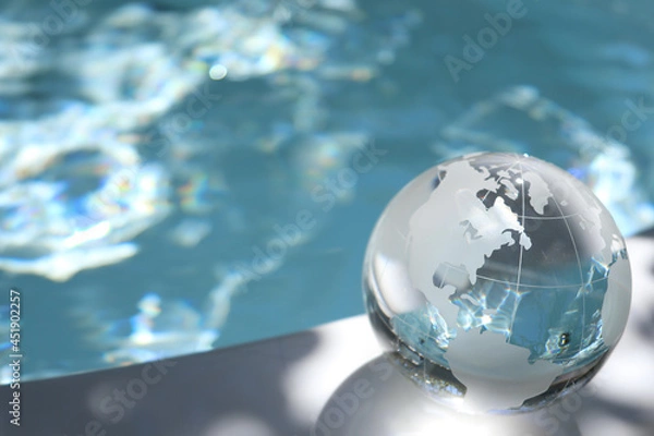 Fototapeta ガラスの地球儀と輝く水面　水の惑星　SDGsなどイメージ　glass globe and shining water surface