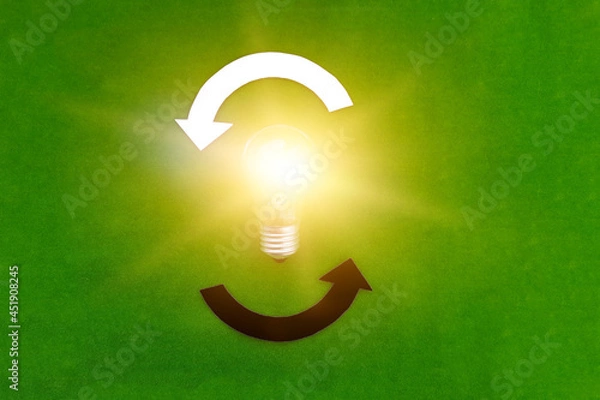 Fototapeta Electric light bulb, two round white and black arrows on a green background. The thought process, business ideas.