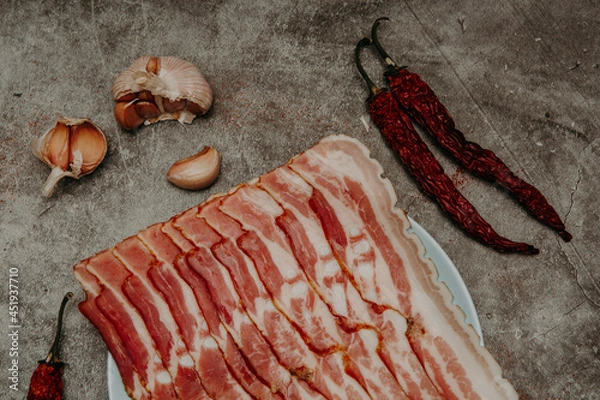 Fototapeta fresh sliced bacon on a gray stone background