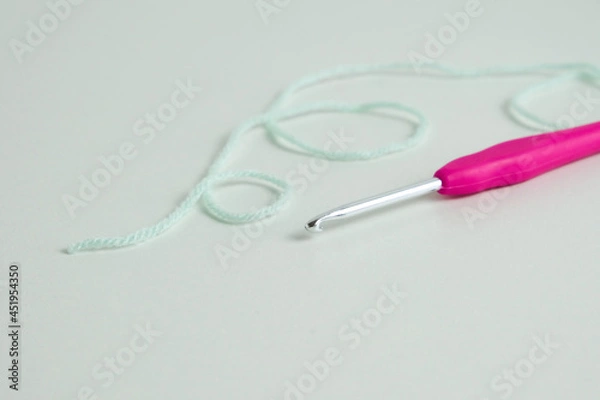 Fototapeta knitting pink crochet hooks and woolen thread on a blue background