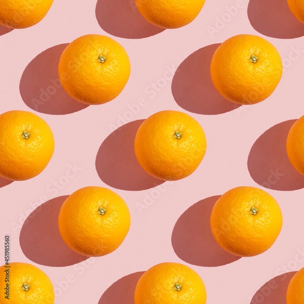 Fototapeta Trendy sunlight summer seamless pattern made with orange slice on pastel light pink background. Minimal summer concept. Flat lay.