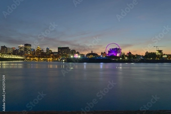 Obraz A skyline of Montreal Old Port and Downtown at the twilight blue hour. Foreground is Saint Lawrence (Laurent) river.